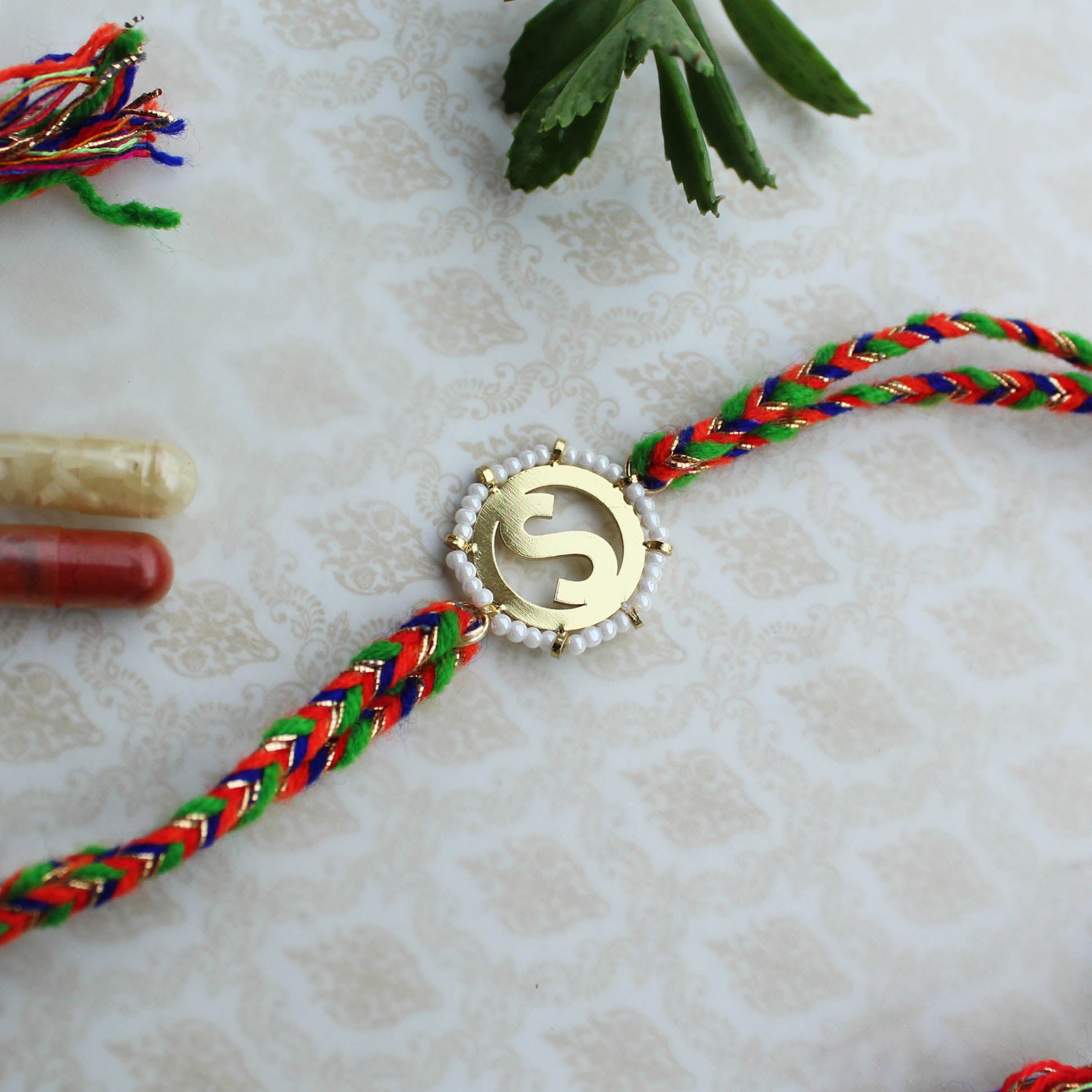 BeAbhika White Beads Gold Tone Customised Initial Name Initial Letter Rakhi Designer Unqiue Famous Rakhi Lightweight Easy To Tie Rakhi Available At Best Price In India Online COD Available Send Rakhi To Brother Small Brother Big Brother Younger Brother Send Rakhi Abroad With Roli Chawal Capsules