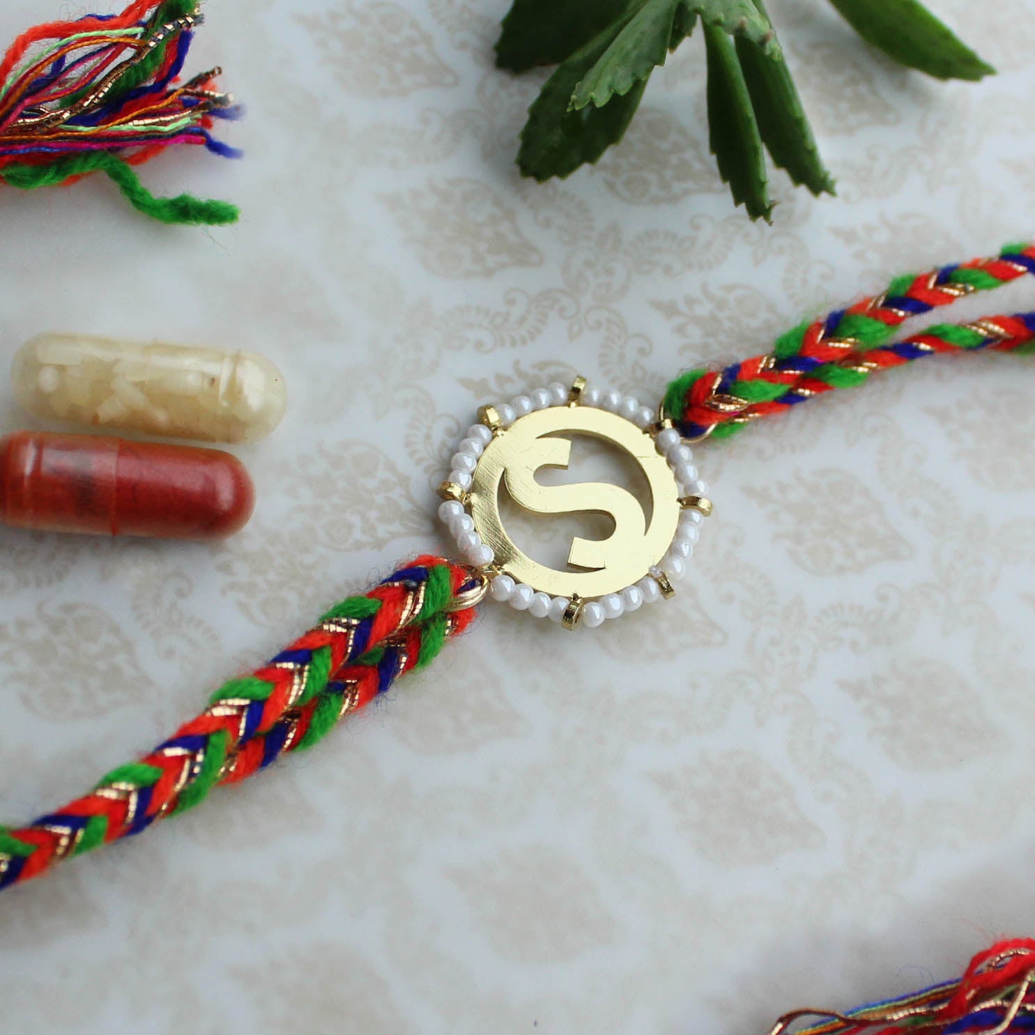 BeAbhika White Beads Gold Tone Customised Initial Name Initial Letter Rakhi Designer Unqiue Famous Rakhi Lightweight Easy To Tie Rakhi Available At Best Price In India Online COD Available Send Rakhi To Brother Small Brother Big Brother Younger Brother Send Rakhi Abroad With Roli Chawal Capsules
