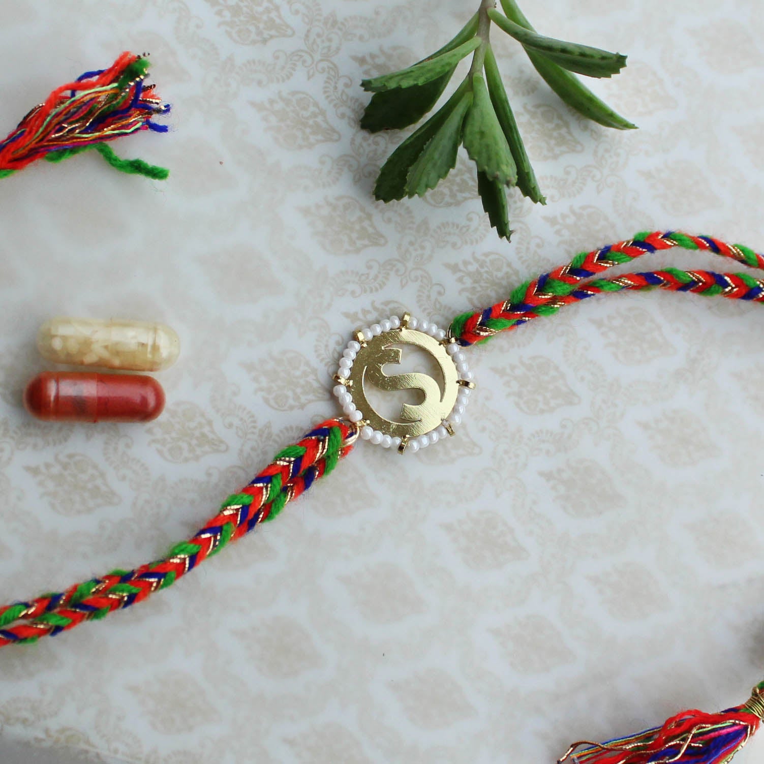 BeAbhika White Beads Gold Tone Customised Initial Name Initial Letter Rakhi Designer Unqiue Famous Rakhi Lightweight Easy To Tie Rakhi Available At Best Price In India Online COD Available Send Rakhi To Brother Small Brother Big Brother Younger Brother Send Rakhi Abroad With Roli Chawal Capsules