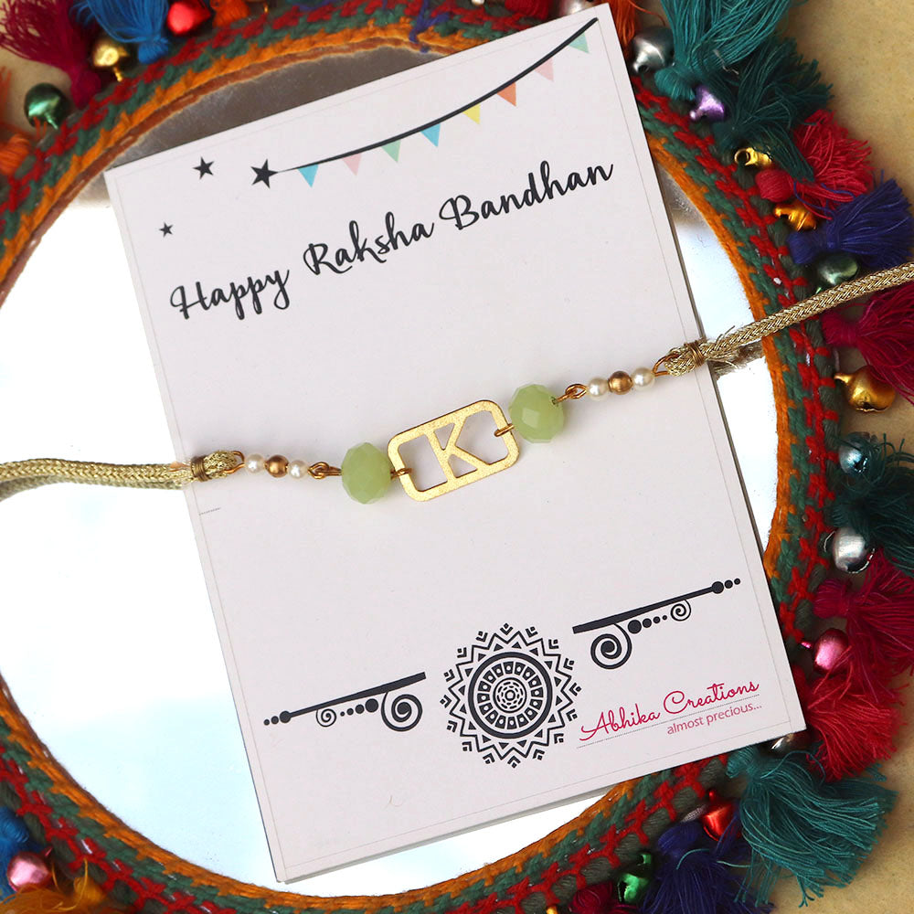 BeAbhika Green Pearl Personalised Initial Rakhi Gold Tone Lightweight Easy To Tie Customised Name Letter Rakhi Available At Best Price In India Online COD Available Send Rakhi To Brother Small Brother Big Brother Younger Brother Send Rakhi Abroad With Roli Chawal Capsules Designer Unqiue Famous