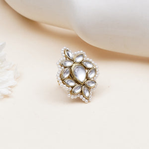 A gold-toned ring featuring a floral cluster of clear teardrop-shaped stones and a border of small white faux pearls.