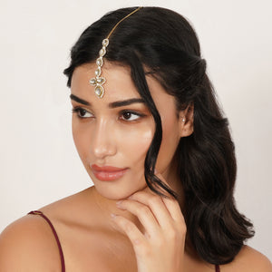 Top view of floral Kundan maangtikka with pearl drop, featuring teardrop glass stones and white faux pearl borders.