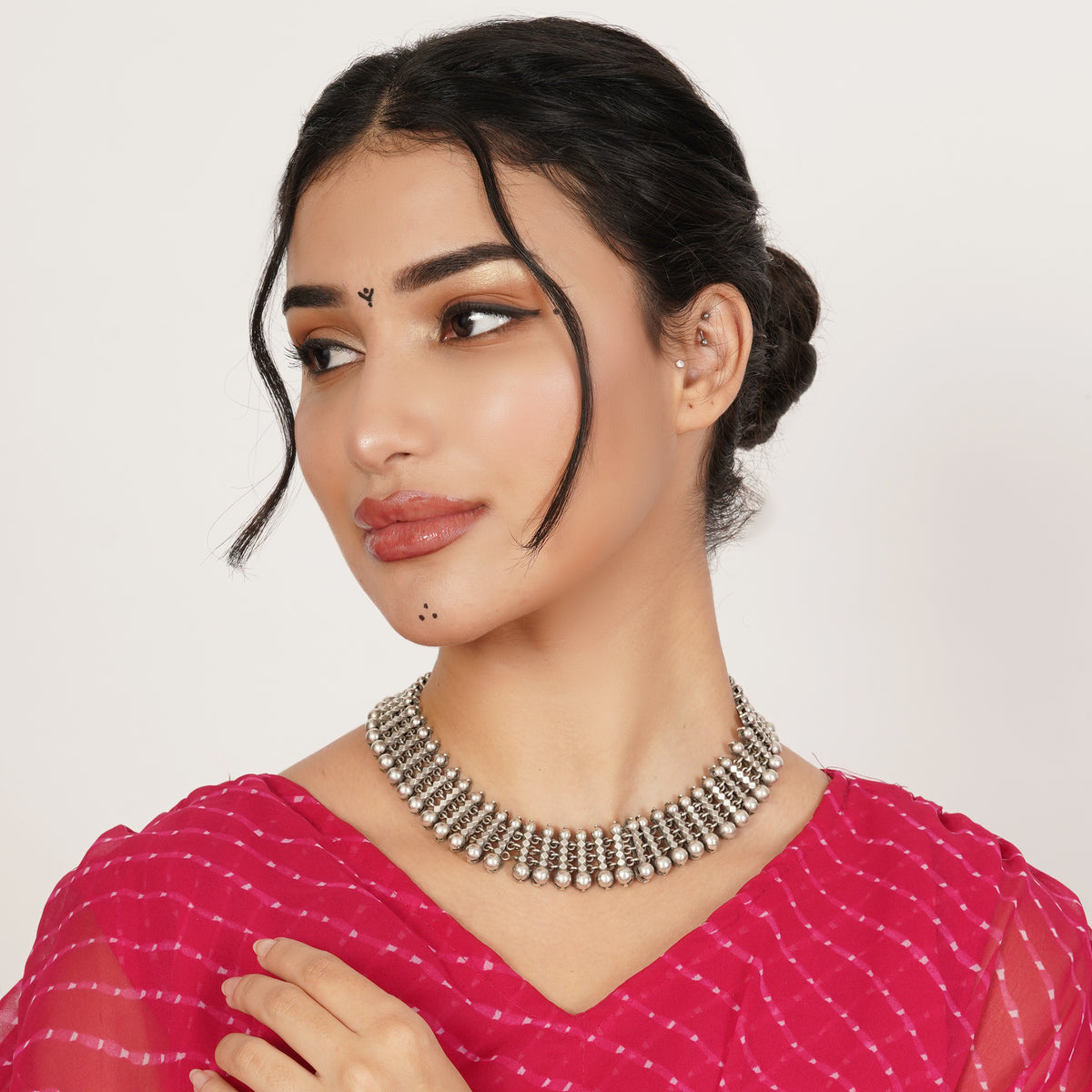 A woman wearing a chunky silver-toned multi-row statement necklace