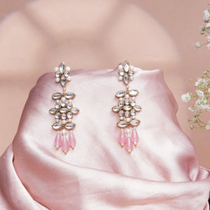 A pair of gold-toned statement dangle earrings with white faux pearls, clear rhinestones, and pink teardrop beads.